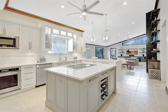 kitchen with stainless steel appliances, a ceiling fan, open floor plan, light countertops, and lofted ceiling