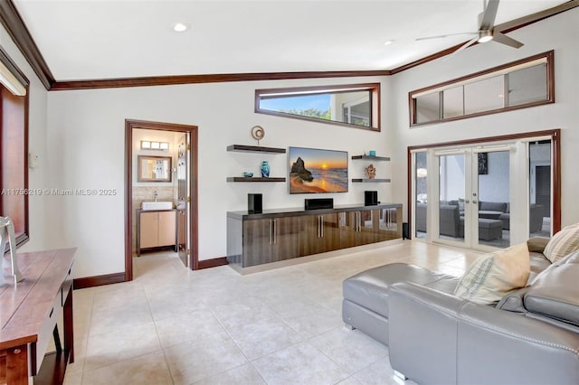 living room featuring crown molding, baseboards, light tile patterned flooring, a ceiling fan, and plenty of natural light