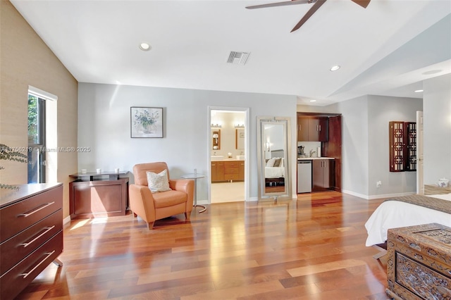 bedroom featuring lofted ceiling, light wood-style flooring, recessed lighting, baseboards, and connected bathroom