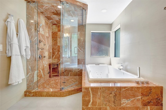 bathroom featuring a tub with jets, a stall shower, and tile patterned flooring