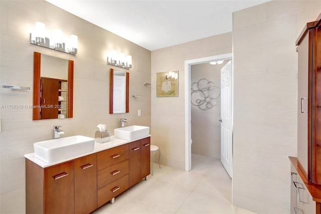 bathroom featuring double vanity, toilet, tile walls, and tile patterned flooring