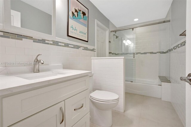 12200 SW 2nd St, Plantation, FL 33325 - bathroom featuring toilet, enclosed tub / shower combo, tile patterned flooring, tile walls, and vanity
