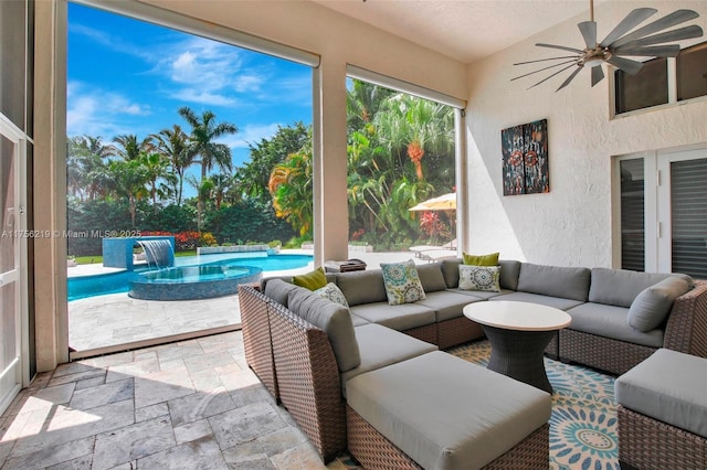 sunroom with stone tile floors, a textured wall, and a jacuzzi
