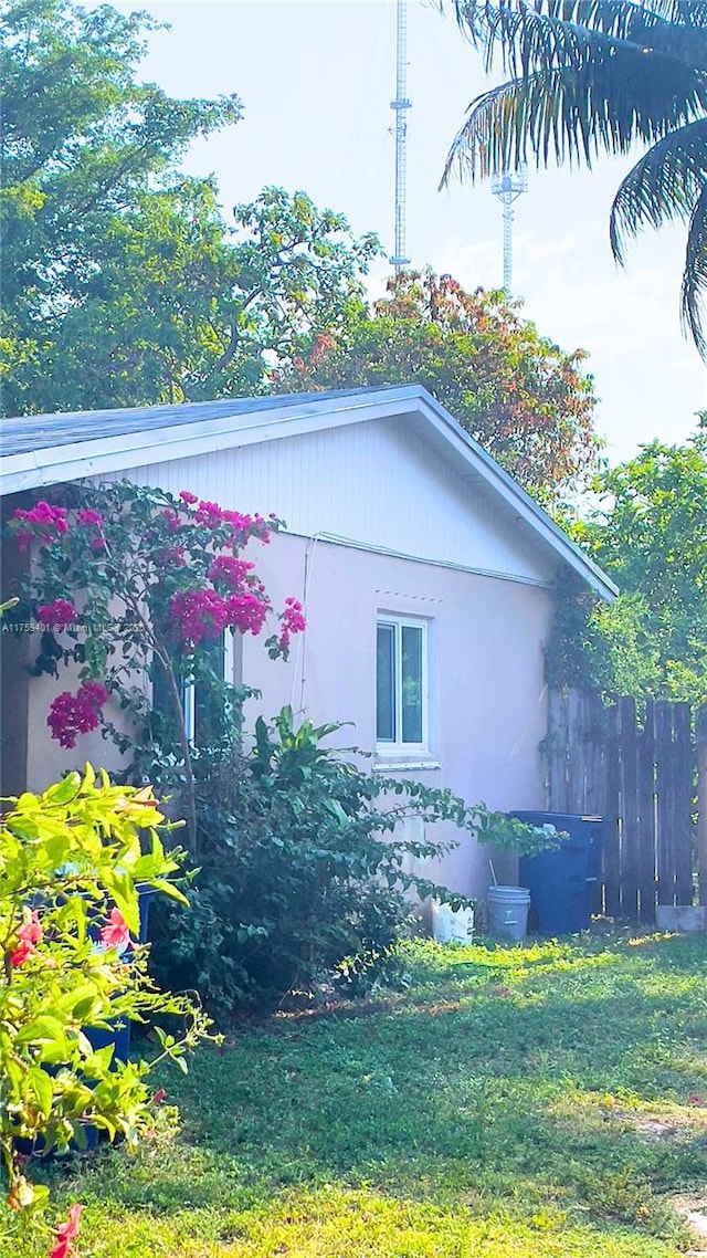 view of property exterior featuring a lawn and fence