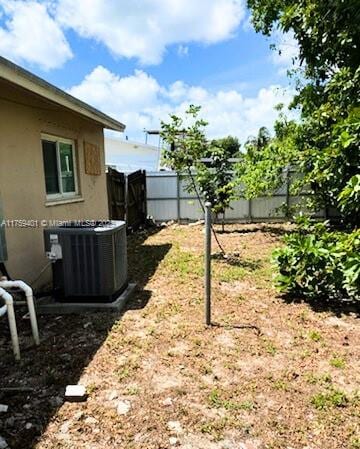 view of yard featuring fence and central AC unit