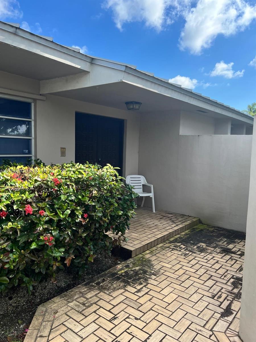 view of exterior entry with a patio and stucco siding