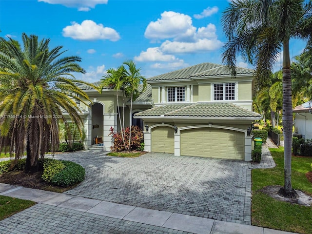 view of front of property with a tile roof, decorative driveway, and stucco siding