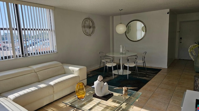 tiled living area featuring a textured ceiling and baseboards