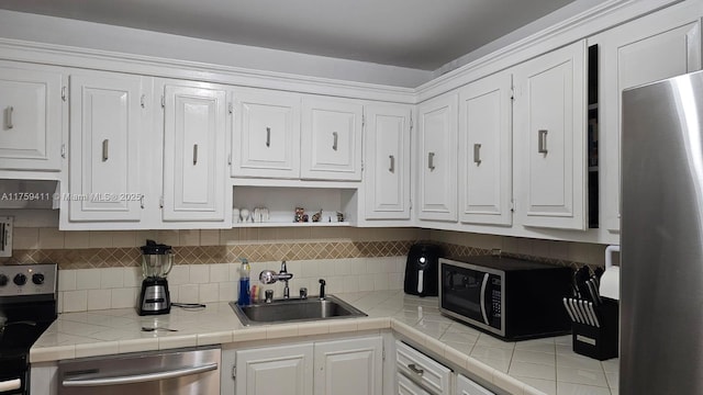 kitchen with appliances with stainless steel finishes, a sink, and white cabinets