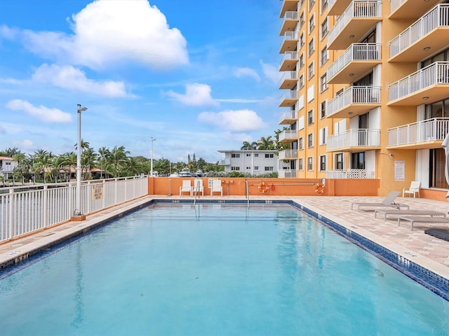 pool with a patio area and fence