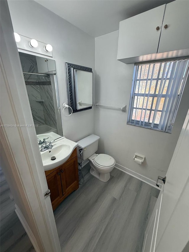 990 NE 212th Ter Unit 990-03, Miami, FL 33179 - full bathroom featuring baseboards, a shower, toilet, wood finished floors, and vanity