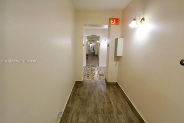 hall featuring baseboards and dark wood finished floors