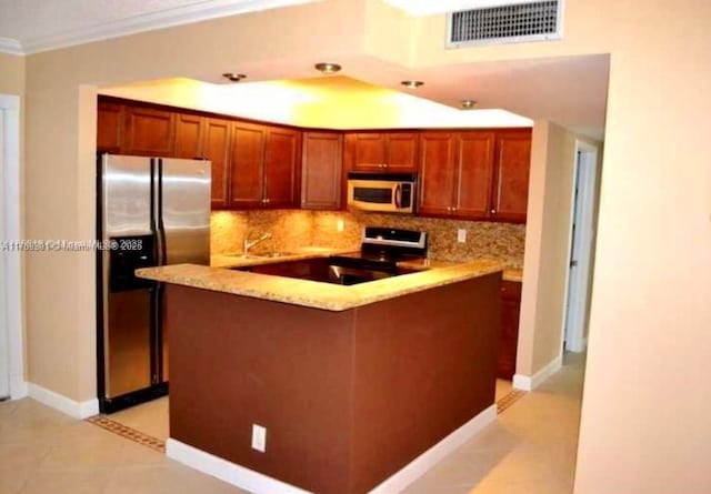 kitchen with appliances with stainless steel finishes, visible vents, ornamental molding, and backsplash