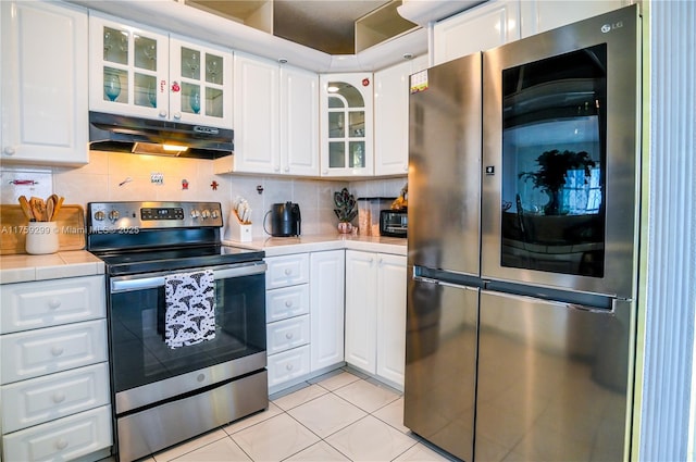 kitchen featuring under cabinet range hood, white cabinetry, stainless steel appliances, and backsplash