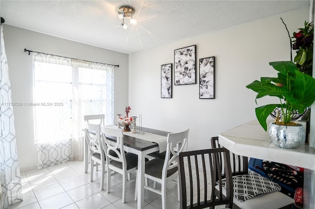 dining area featuring tile patterned flooring and a textured ceiling