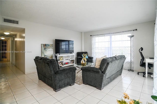 living area featuring light tile patterned floors and visible vents