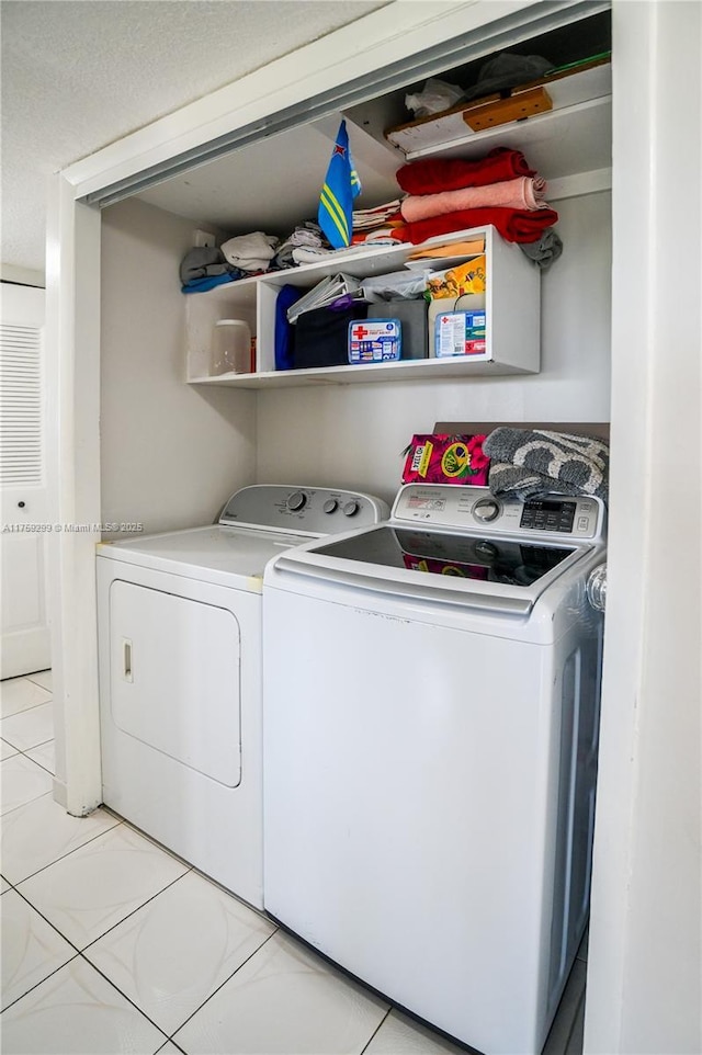 washroom featuring laundry area, separate washer and dryer, and light tile patterned flooring