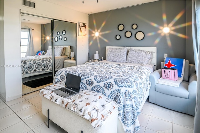 tiled bedroom featuring a closet and visible vents