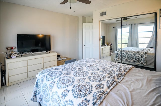 bedroom featuring light tile patterned floors, a closet, visible vents, and a ceiling fan