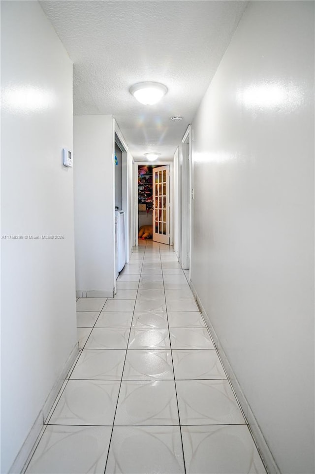 corridor with baseboards and a textured ceiling