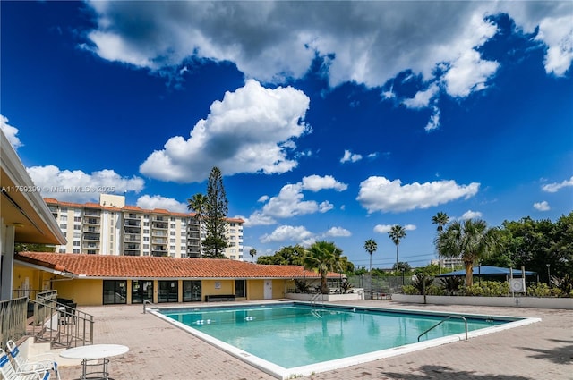 community pool featuring fence and a patio