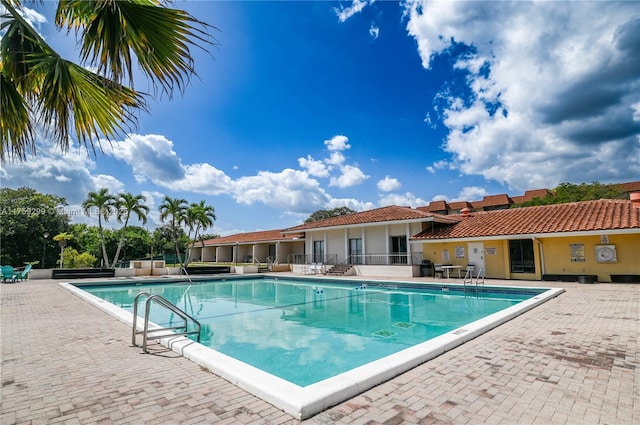 pool with a patio and fence