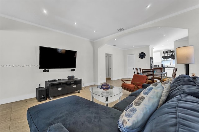 living area with arched walkways, crown molding, and baseboards