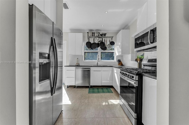 kitchen with dark countertops, visible vents, backsplash, appliances with stainless steel finishes, and white cabinets