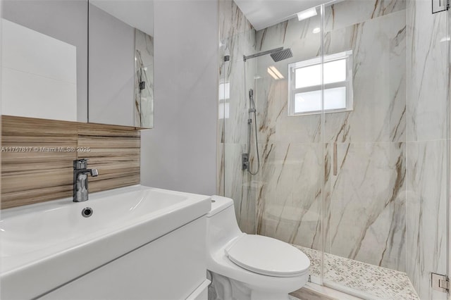 bathroom with vanity, a marble finish shower, and toilet