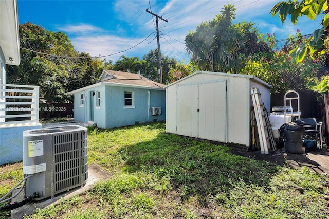 view of shed with fence and central AC unit