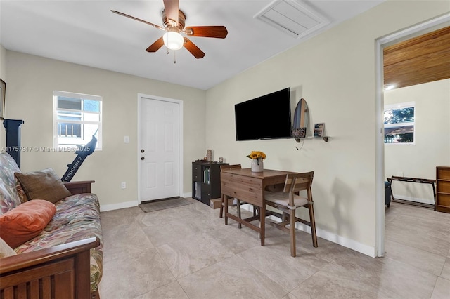 living area with visible vents, attic access, baseboards, and a ceiling fan