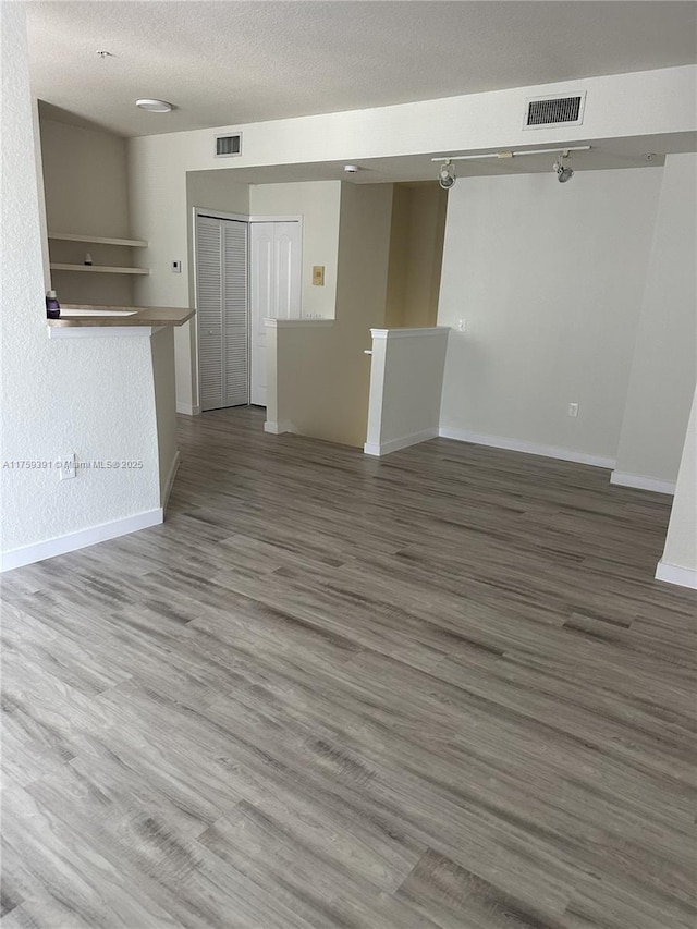 spare room with visible vents, a textured ceiling, and wood finished floors