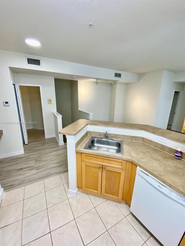 kitchen with a sink, visible vents, dishwasher, and light tile patterned floors