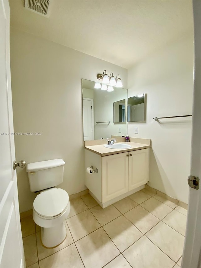 bathroom featuring tile patterned flooring, visible vents, toilet, and vanity