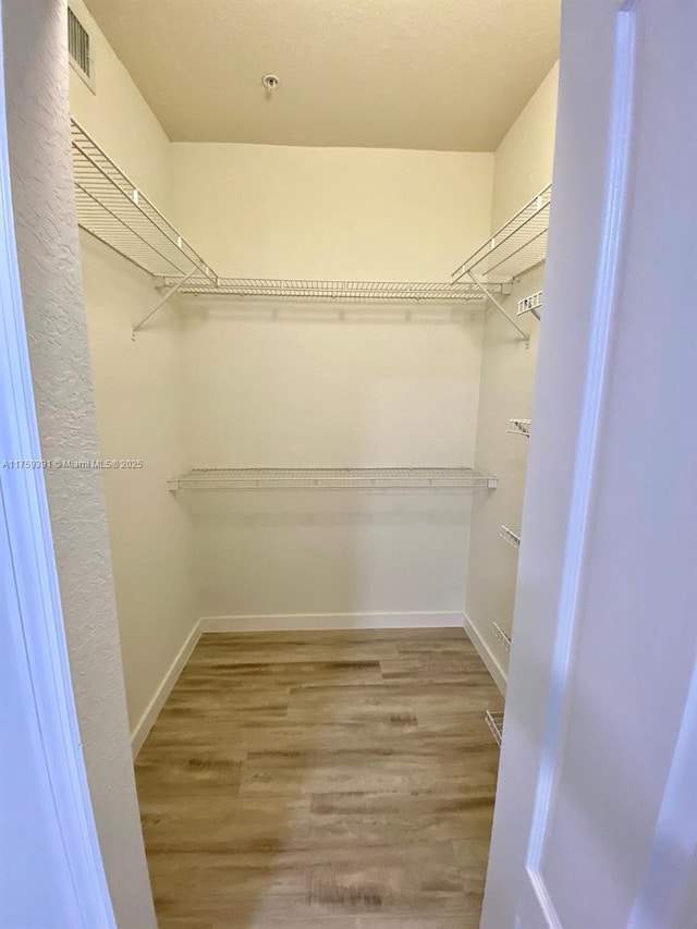 spacious closet with wood finished floors and visible vents