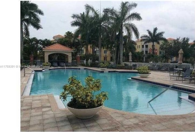 pool with a patio area and fence