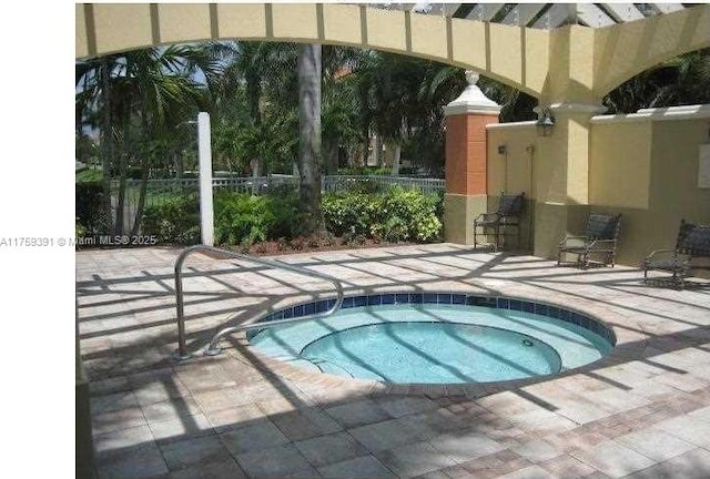 view of pool featuring a patio, fence, and a hot tub