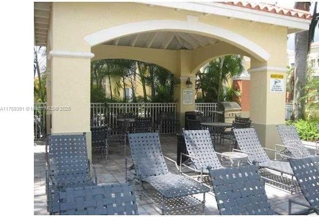 view of patio featuring area for grilling and fence