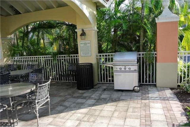 view of patio featuring outdoor dining area, area for grilling, and fence