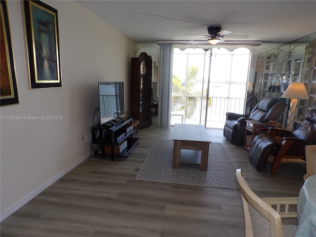 living room featuring ceiling fan, wood finished floors, and baseboards