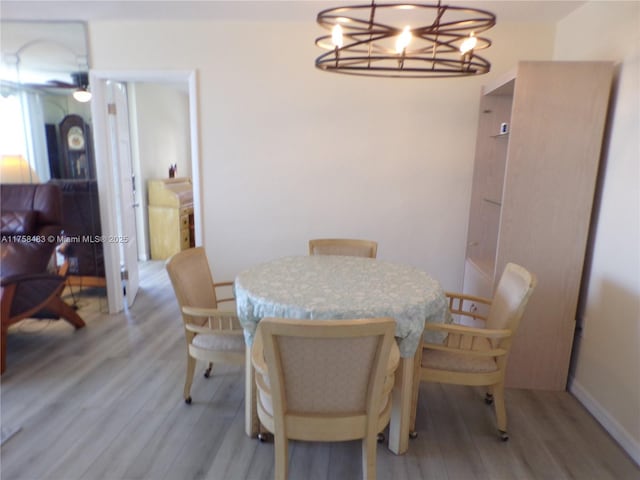 dining room featuring light wood finished floors, ceiling fan, and baseboards