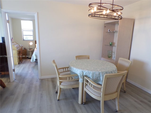 dining room featuring radiator heating unit, light wood-type flooring, and baseboards