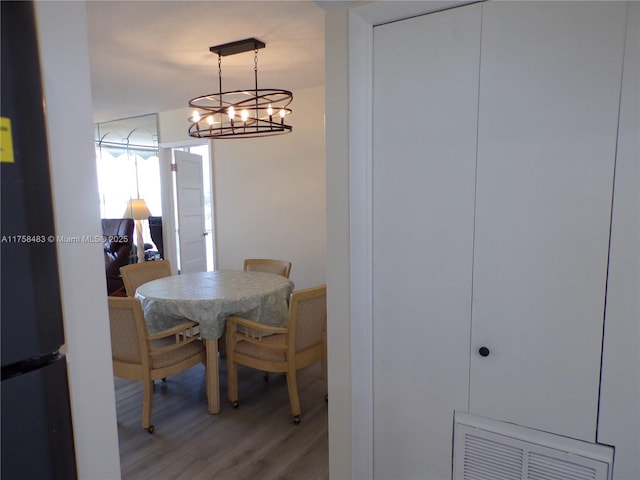 dining space with light wood-type flooring and visible vents