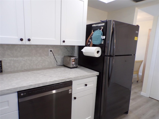 kitchen with dishwashing machine, white cabinetry, light wood-style floors, backsplash, and freestanding refrigerator