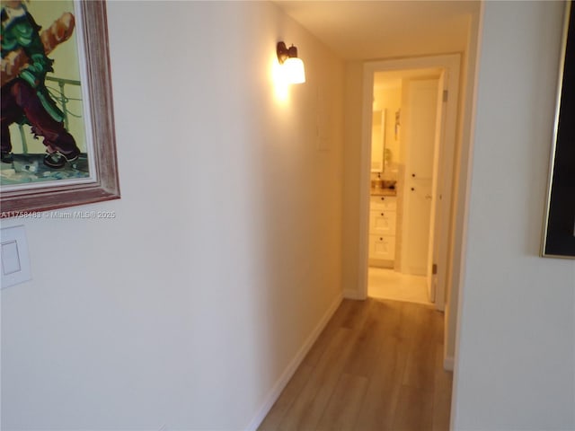 hall with baseboards and wood finished floors