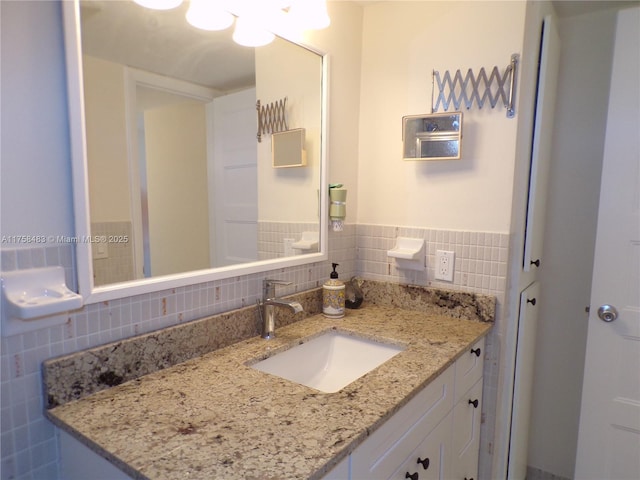 bathroom with a wainscoted wall, tile walls, and vanity