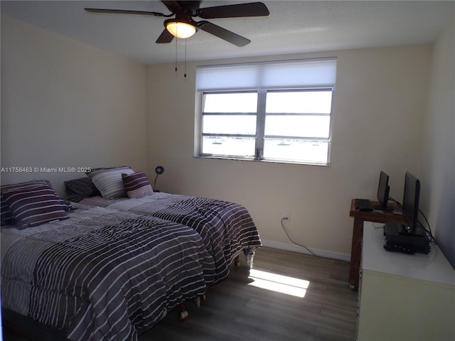 bedroom with ceiling fan, baseboards, and wood finished floors