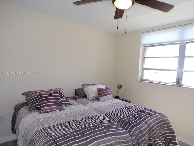 bedroom with a ceiling fan and baseboards