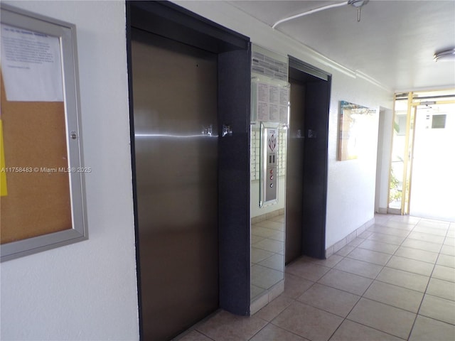 corridor with tile patterned flooring and elevator