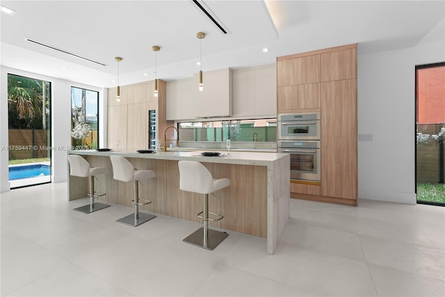1823 NE 26th Ave, Fort Lauderdale, FL 33305 - kitchen featuring modern cabinets, a breakfast bar area, light countertops, and stainless steel double oven